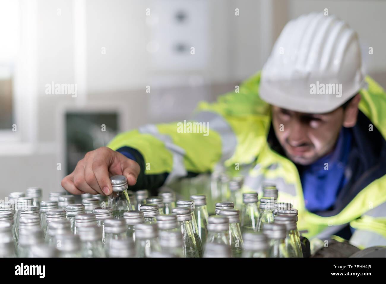 Fabbrica di alimenti o bevande, il tecnico controlla il trasportatore per bottiglie di alimentazione, alimenti o bevande in magazzino prima di inviare il prodotto al cliente. Qualità Foto Stock