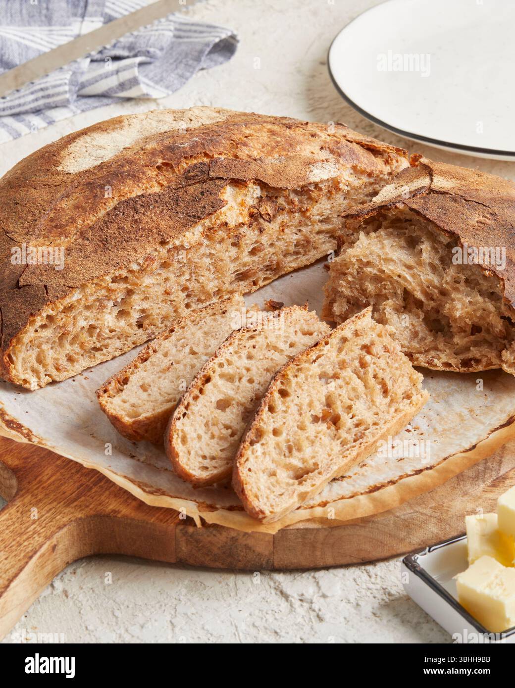 Pane di farro germogliato su una superficie di legno con olio d'oliva e burro sullo sfondo: Un pane rustico e ricco di nutrienti, perfetto per mangiare in modo pulito e per la colazione Foto Stock Pane di farro germogliato su una superficie di legno con olio d'oliva e burro sullo sfondo: Un pane rustico e ricco di nutrienti, perfetto per mangiare in modo pulito e per la colazione Foto Stock