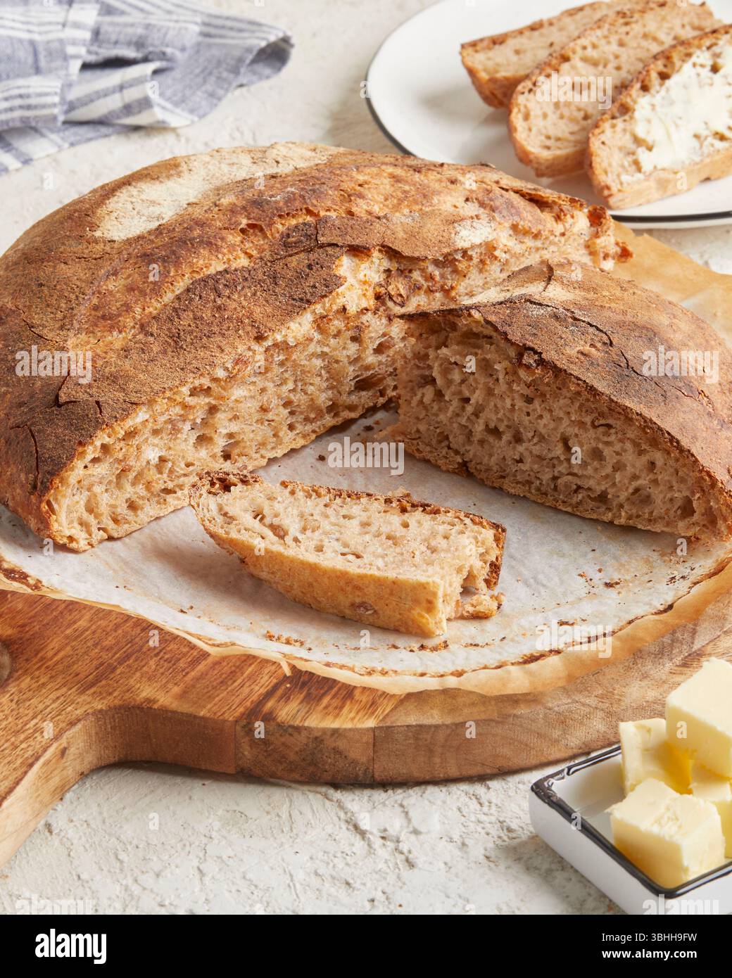 Pane di farro germogliato su una superficie di legno con olio d'oliva e burro sullo sfondo: Un pane rustico e ricco di nutrienti, perfetto per mangiare in modo pulito e per la colazione Foto Stock Pane di farro germogliato su una superficie di legno con olio d'oliva e burro sullo sfondo: Un pane rustico e ricco di nutrienti, perfetto per mangiare in modo pulito e per la colazione Foto Stock