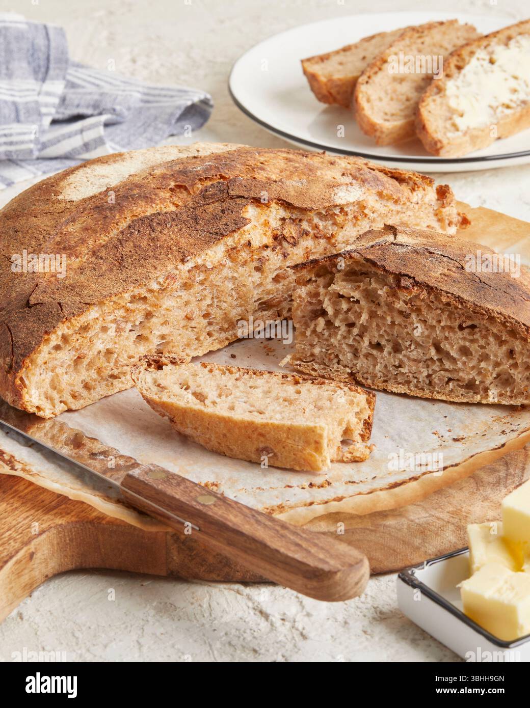 Pane di farro germogliato su una superficie di legno con olio d'oliva e burro sullo sfondo: Un pane rustico e ricco di nutrienti, perfetto per mangiare in modo pulito e per la colazione Foto Stock Pane di farro germogliato su una superficie di legno con olio d'oliva e burro sullo sfondo: Un pane rustico e ricco di nutrienti, perfetto per mangiare in modo pulito e per la colazione Foto Stock