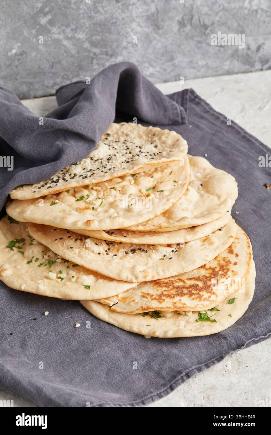 Nan al coriandolo all'aglio: Una focaccia indiana tradizionale ricoperta di erbe aromatiche, perfetta come contorno per curry, piatti tandoori o piatti di Street food Foto Stock