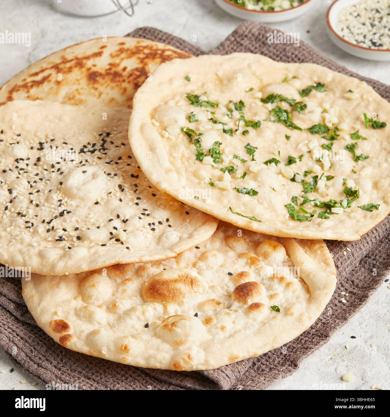 Nan al coriandolo all'aglio: Una focaccia indiana tradizionale ricoperta di erbe aromatiche, perfetta come contorno per curry, piatti tandoori o piatti di Street food Foto Stock