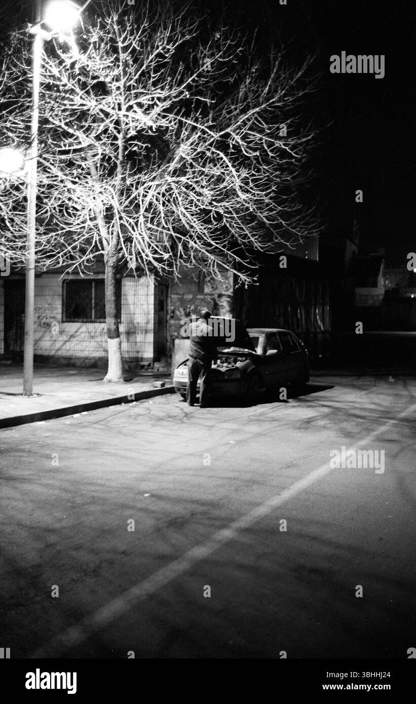 Riparazione di automobili notturne della fine degli anni '2000 sotto Streetlamp, Cina Foto Stock