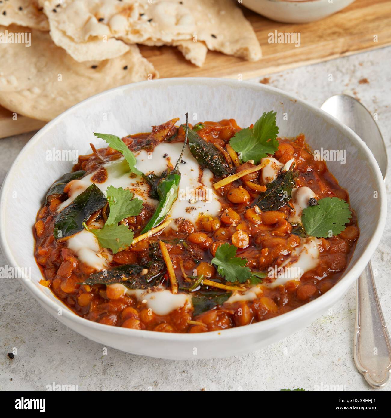 Chana dal in una ciotola con focaccia sul lato, un sostanzioso piatto di lenticchie ayurvediche indiane, perfetto per un pranzo vegano, cibo curativo o una cena confortevole Foto Stock