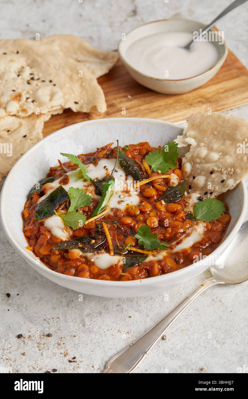 Chana dal in una ciotola con focaccia sul lato, un sostanzioso piatto di lenticchie ayurvediche indiane, perfetto per un pranzo vegano, cibo curativo o una cena confortevole Foto Stock