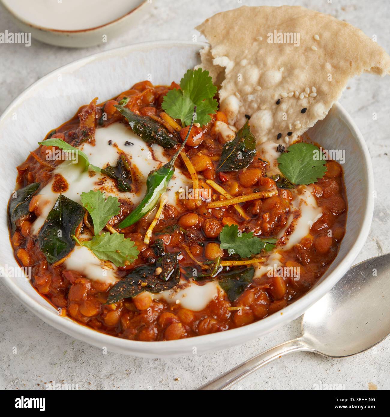 Chana dal in una ciotola con focaccia sul lato, un sostanzioso piatto di lenticchie ayurvediche indiane, perfetto per un pranzo vegano, cibo curativo o una cena confortevole Foto Stock