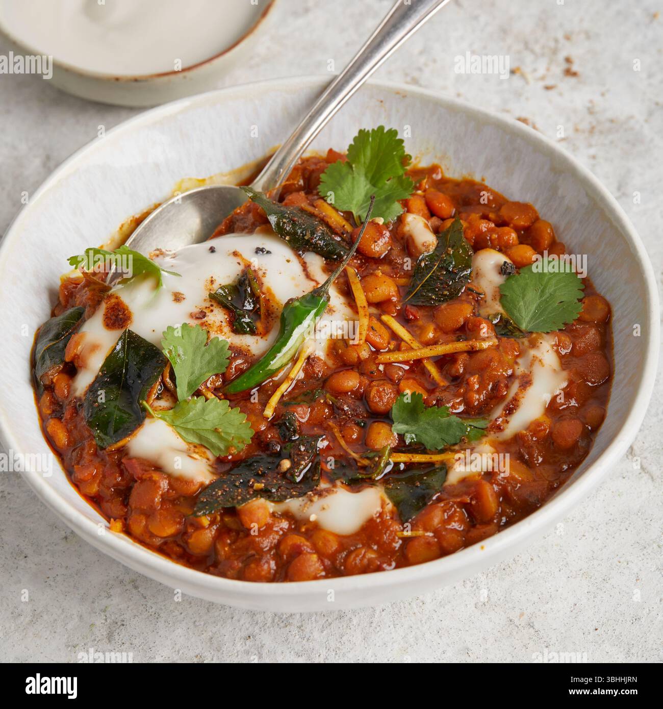 Chana dal in una ciotola con focaccia sul lato, un sostanzioso piatto di lenticchie ayurvediche indiane, perfetto per un pranzo vegano, cibo curativo o una cena confortevole Foto Stock