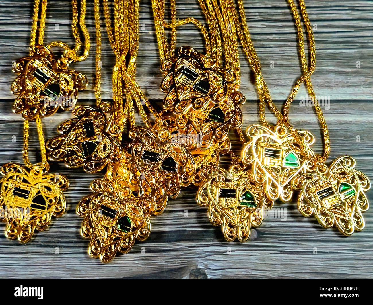 Collane dorate con l'immagine della moschea del profeta e della Kaaba, una collana è un articolo di gioielli che viene indossato intorno al collo, come decorazione e fashi Foto Stock