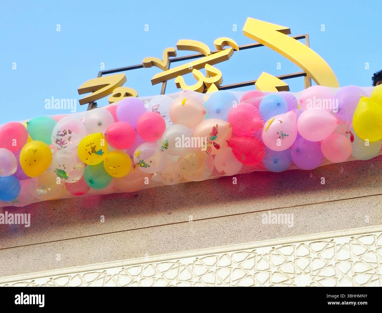 Traduzione di testo arabo (Allah, il Dio), celebrazioni festive in una moschea al Cairo con decine di palloncini tenuti nel tetto della moschea accanto alla miniera Foto Stock