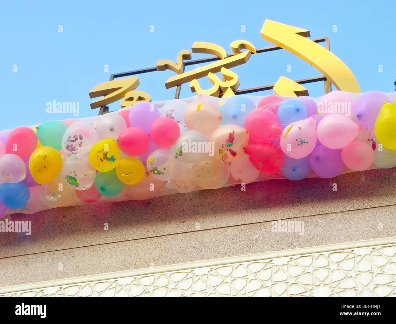 Traduzione di testo arabo (Allah, il Dio), celebrazioni festive in una moschea al Cairo con decine di palloncini tenuti nel tetto della moschea accanto alla miniera Foto Stock