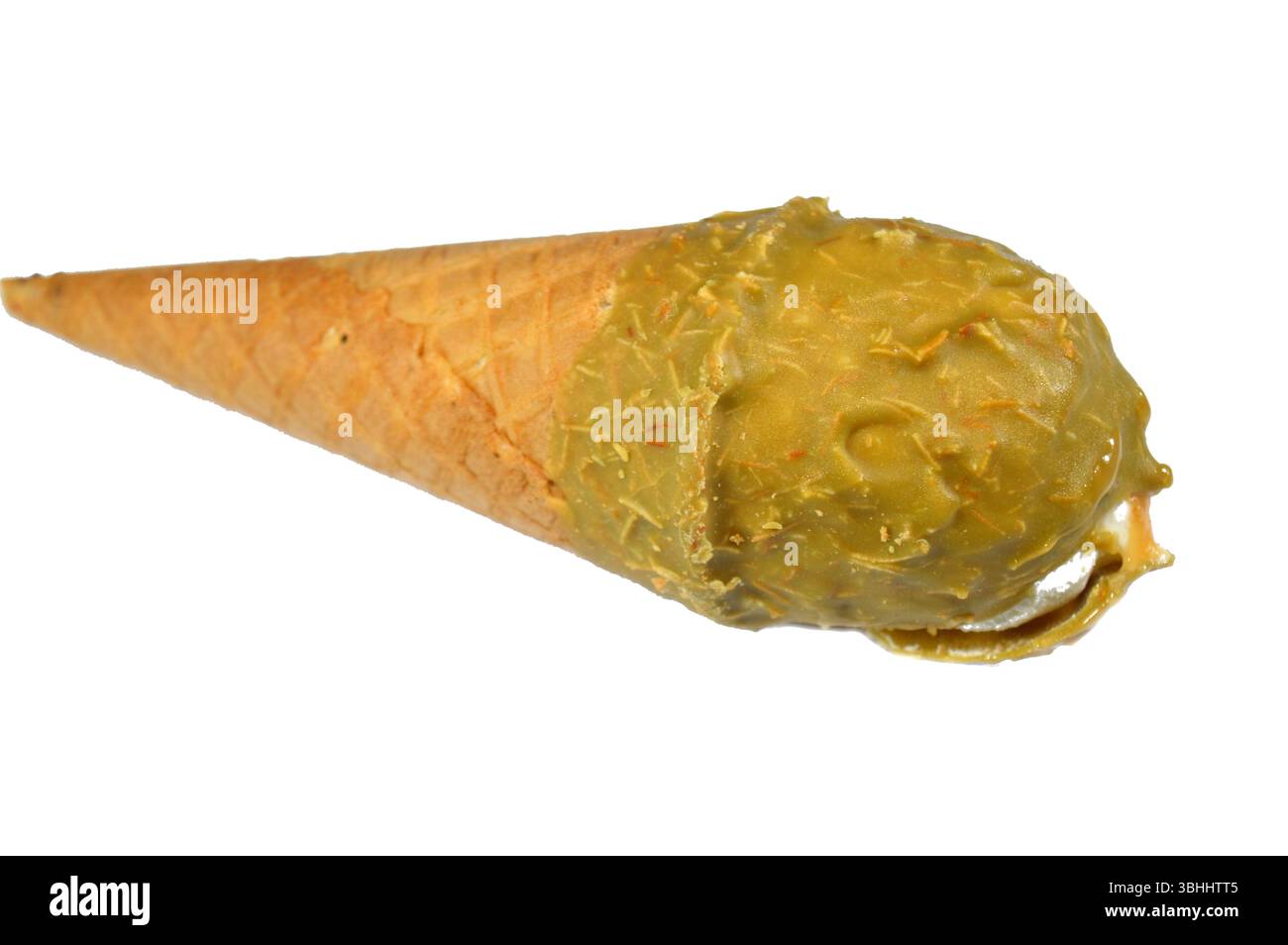 Gelato cono alla vaniglia con caramello ricoperto di strato di pistacchio e Kunafa Konafa e noci in un cono croccante di cialda, sciogliendo il gelato freddo girano in un Foto Stock