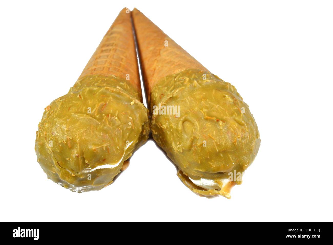 Gelato cono alla vaniglia con caramello ricoperto di strato di pistacchio e Kunafa Konafa e noci in un cono croccante di cialda, sciogliendo il gelato freddo girano in un Foto Stock