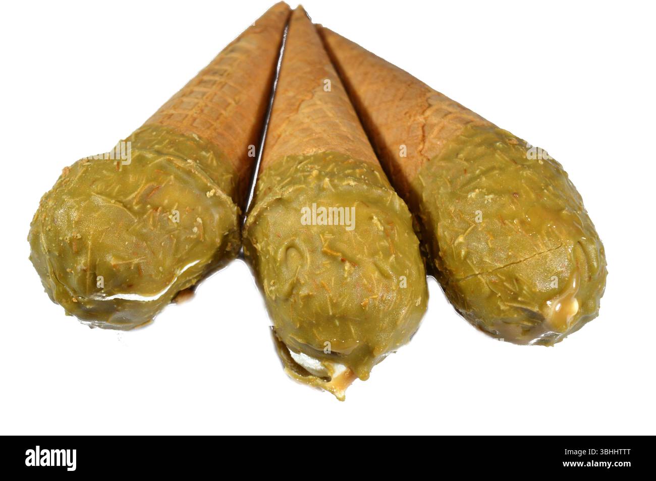 Gelato cono alla vaniglia con caramello ricoperto di strato di pistacchio e Kunafa Konafa e noci in un cono croccante di cialda, sciogliendo il gelato freddo girano in un Foto Stock