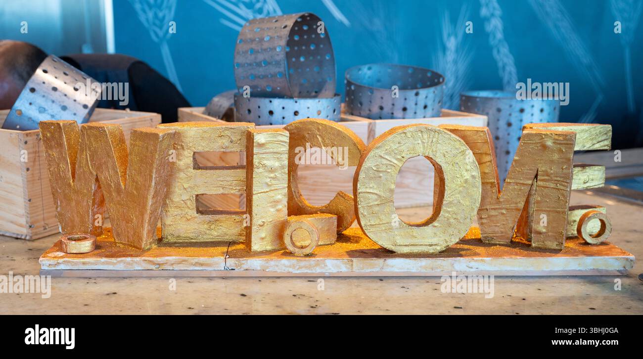 Parola d'oro di benvenuto visualizzata sul Bakery buffet Foto Stock