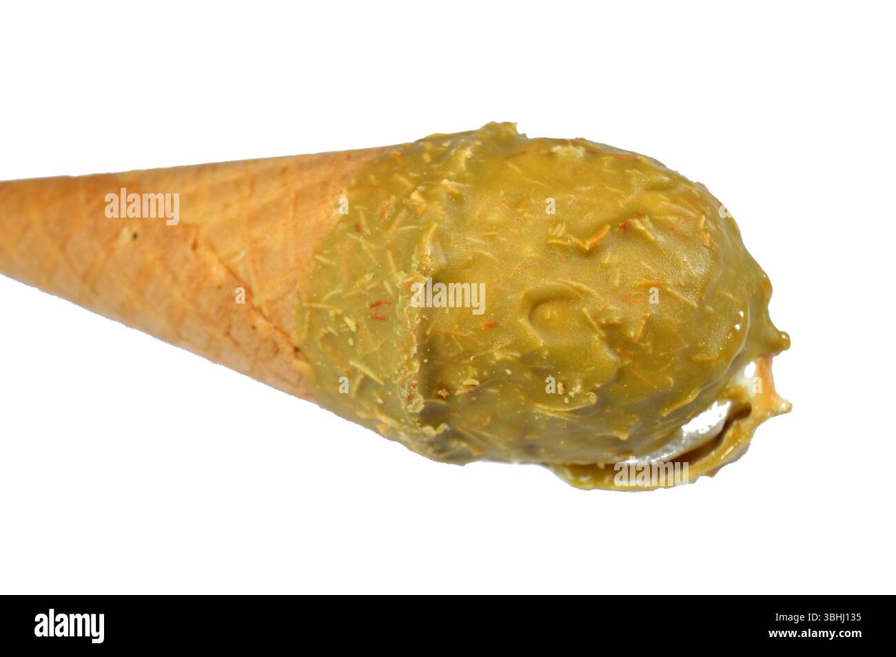 Gelato cono alla vaniglia con caramello ricoperto di strato di pistacchio e Kunafa Konafa e noci in un cono croccante di cialda, sciogliendo il gelato freddo girano in un Foto Stock