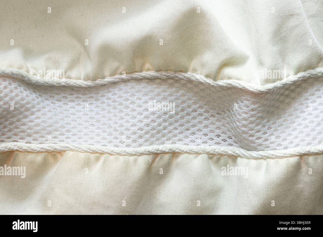 Cuscino in tessuto leggero con inserto centrale in rete traspirante e morbide pieghe, primo piano di tessuto Foto Stock