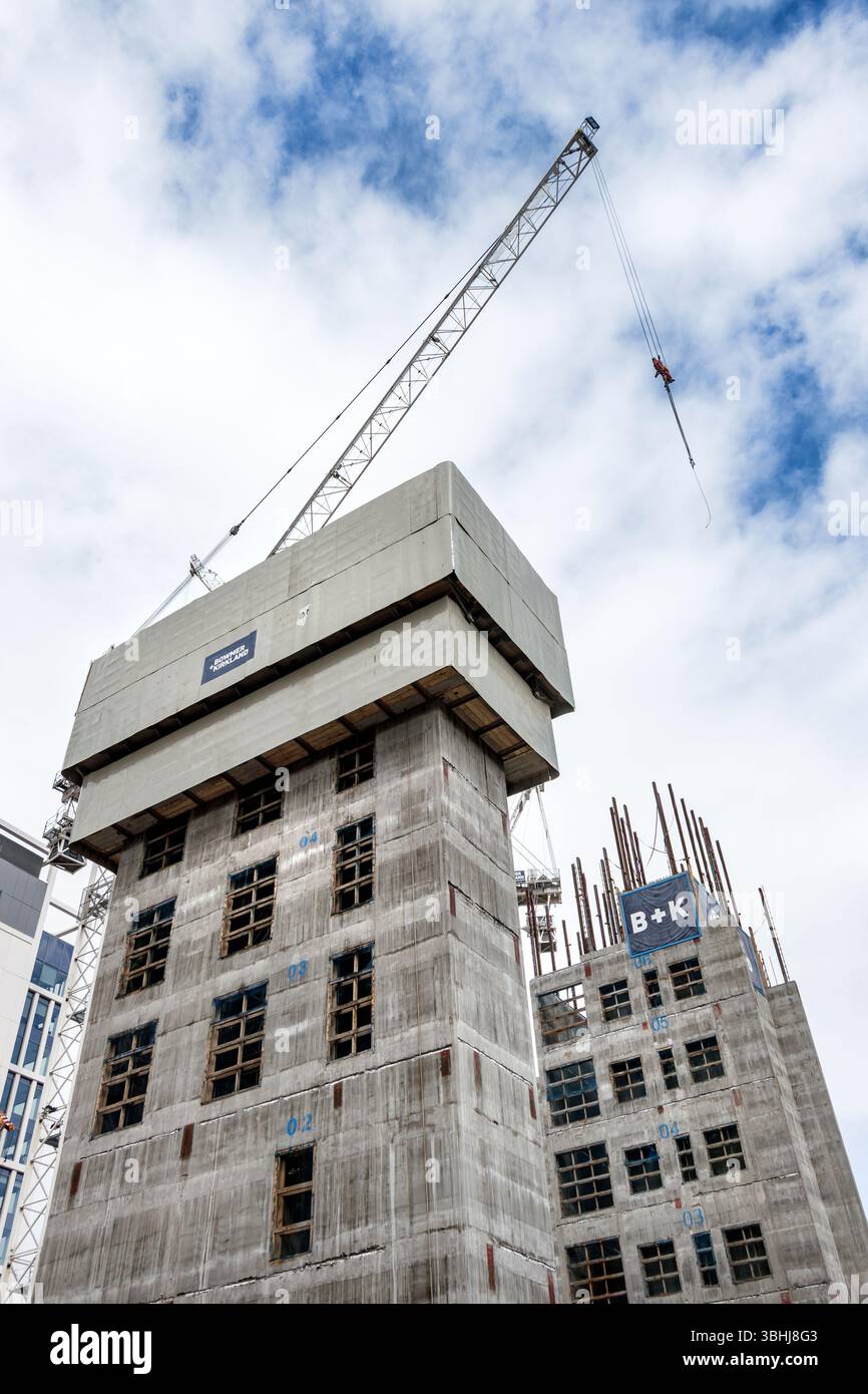 Cantiere con grattacieli in fase di sviluppo con una gru prominente e un nucleo di servizio in cemento Foto Stock