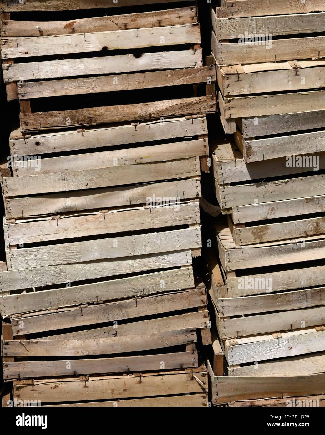 Una pila di scatole vuote di frutta e verdura in legno in un mercato alimentare Foto Stock