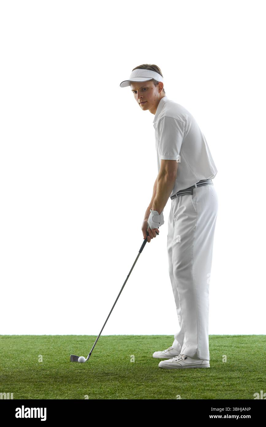 Vista laterale di un golfista sicuro con visiera e guanti che si preparano a fare un swing mentre si guarda avanti in una concentrazione silenziosa. Foto Stock