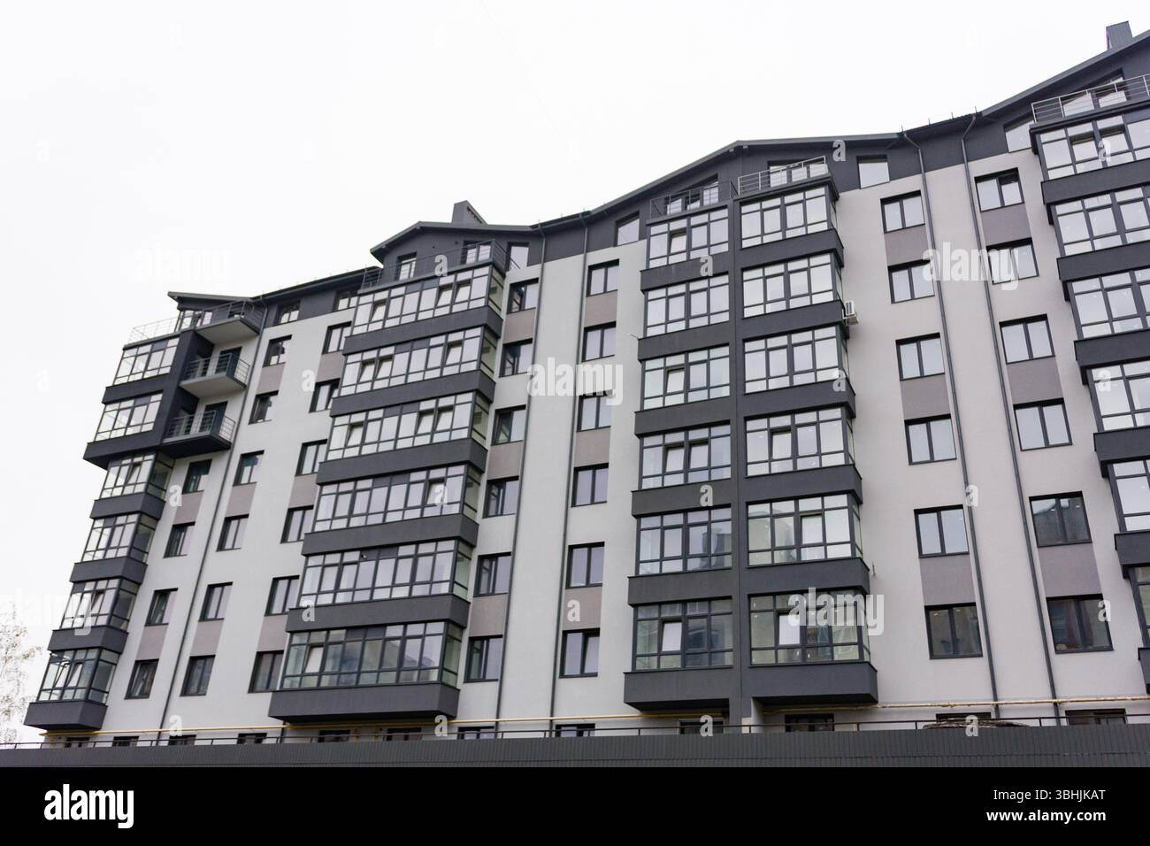 Linee eleganti e grandi finestre definiscono questo moderno edificio di appartamenti situato in un quartiere vivace, che unisce design moderno e comfort urbano Foto Stock