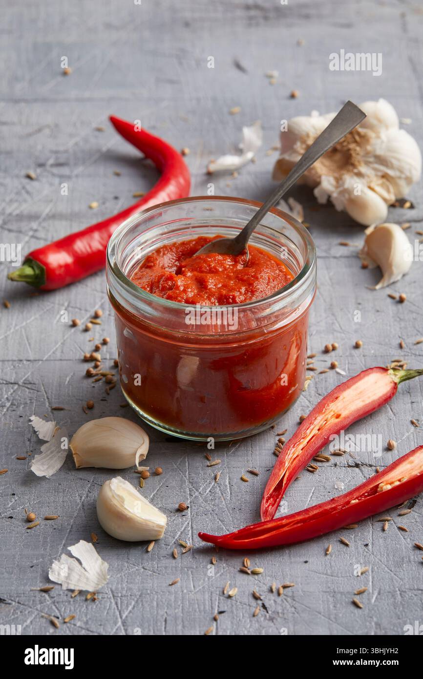 Pasta di Harissa, una pasta piccante di peperoncino nordafricano fatta con peperoni rossi, aglio e spezie Foto Stock