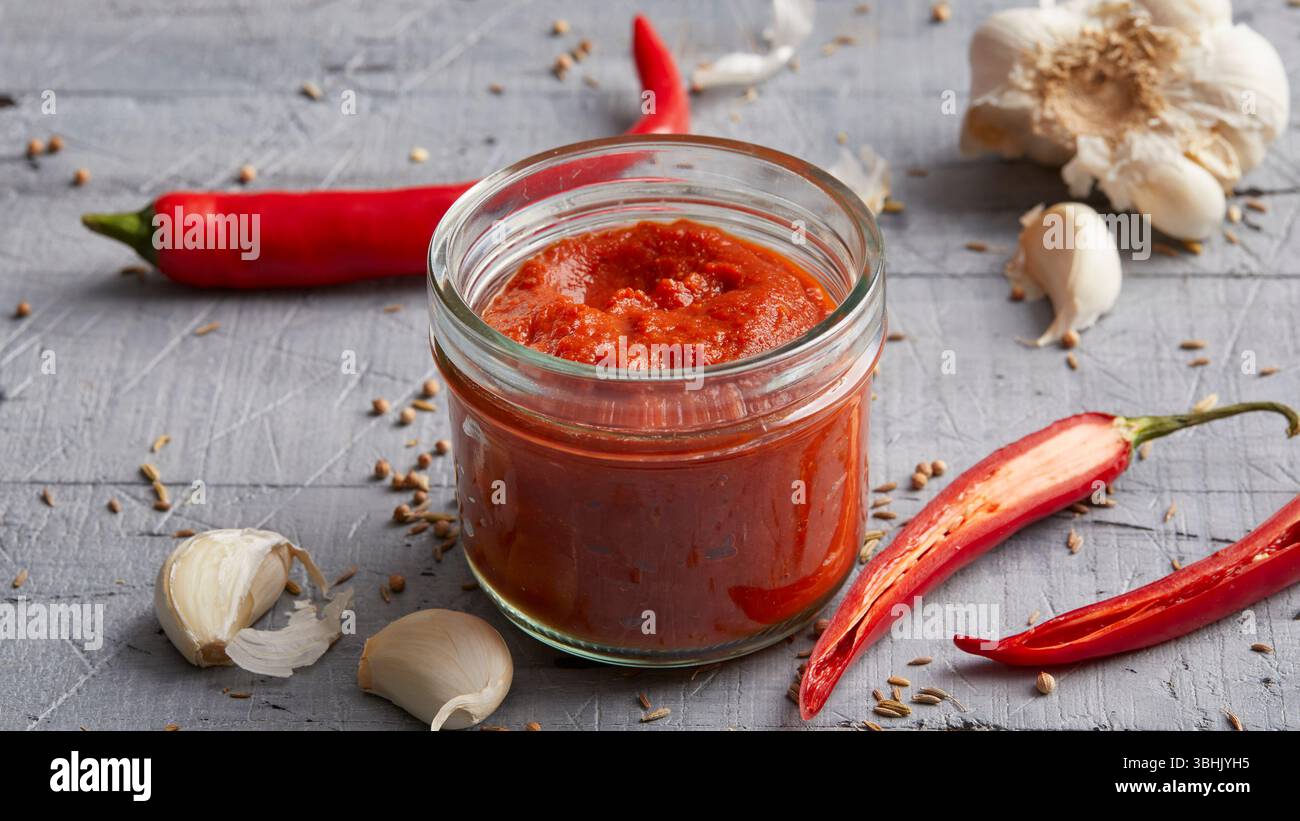 Pasta di Harissa, una pasta piccante di peperoncino nordafricano fatta con peperoni rossi, aglio e spezie Foto Stock
