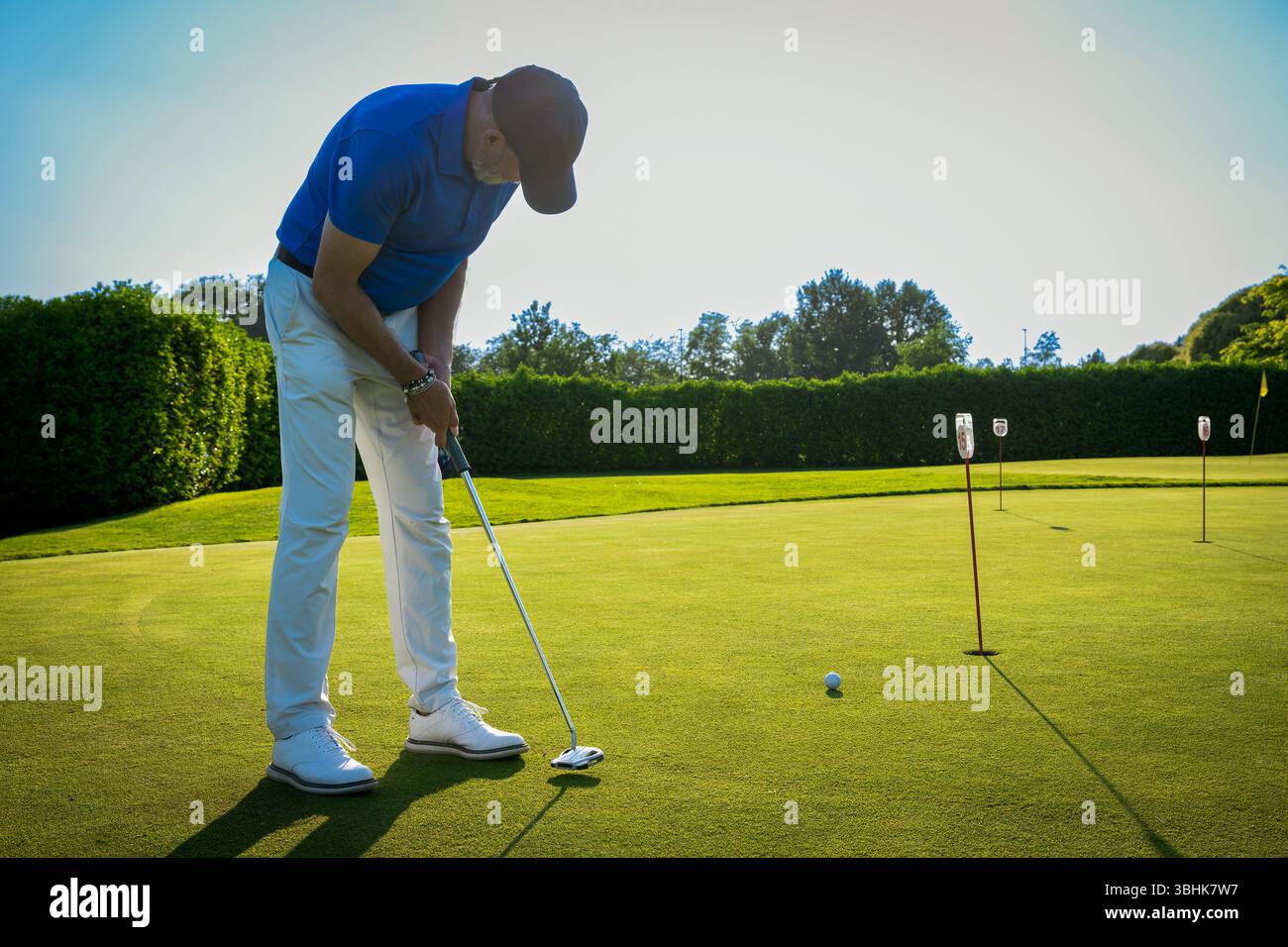 Il golfista mette sul green di uno splendido campo da golf durante una giornata di sole Foto Stock