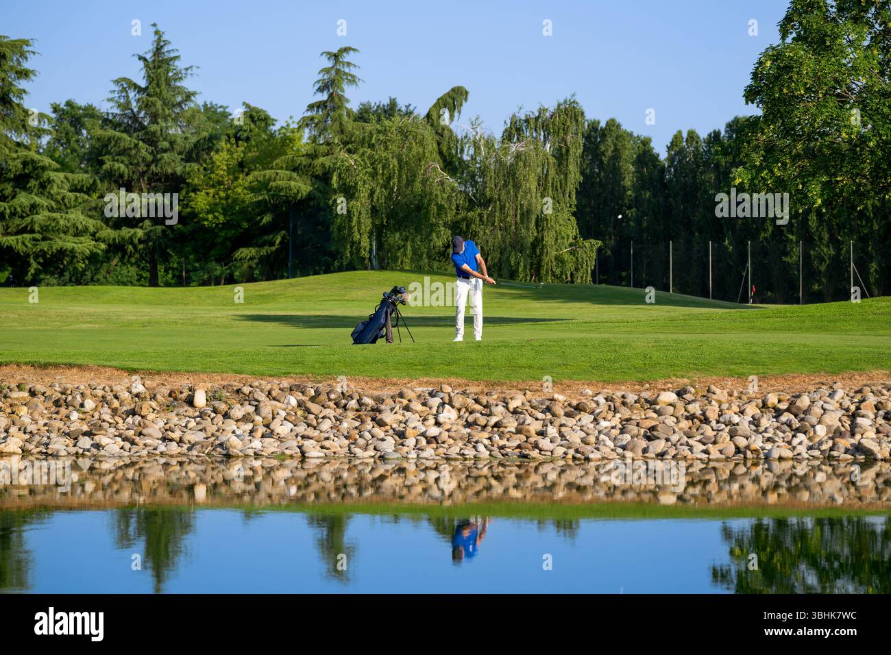 Golfista professionista che batte la palla in una giornata di sole su uno splendido campo da golf Foto Stock