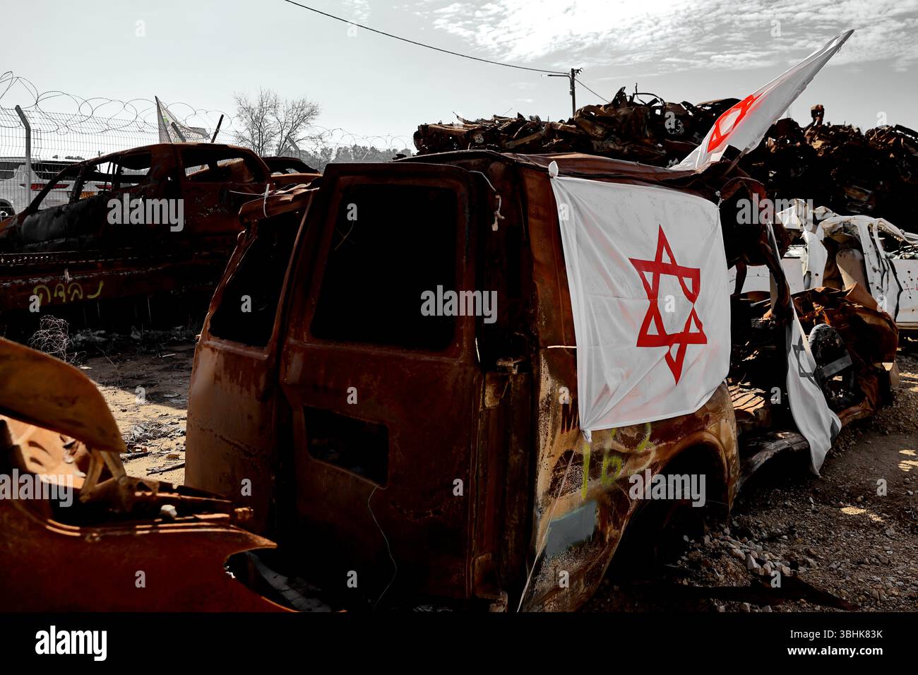 Un mucchio di auto carbonizzate drappeggiate con bandiere israeliane si trova a ovest di Tkuma nella busta di Gaza, formando un inquietante memoriale delle mura delle auto per la resilienza assediata Foto Stock