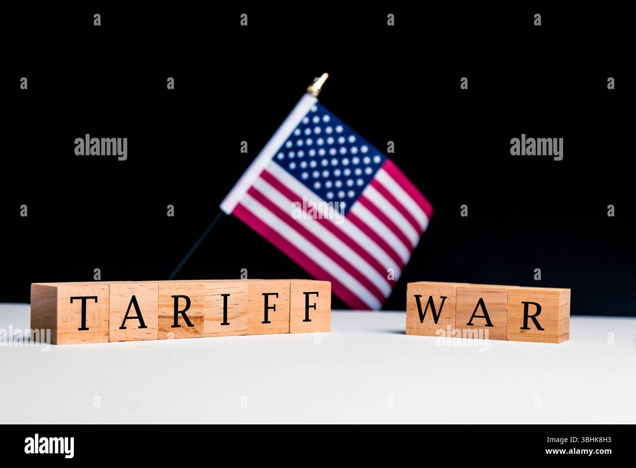 Concetto degli Stati Uniti d'America, con un focus selettivo sulla bandiera degli Stati Uniti insieme a un cartello che legge guerra tariffaria Foto Stock