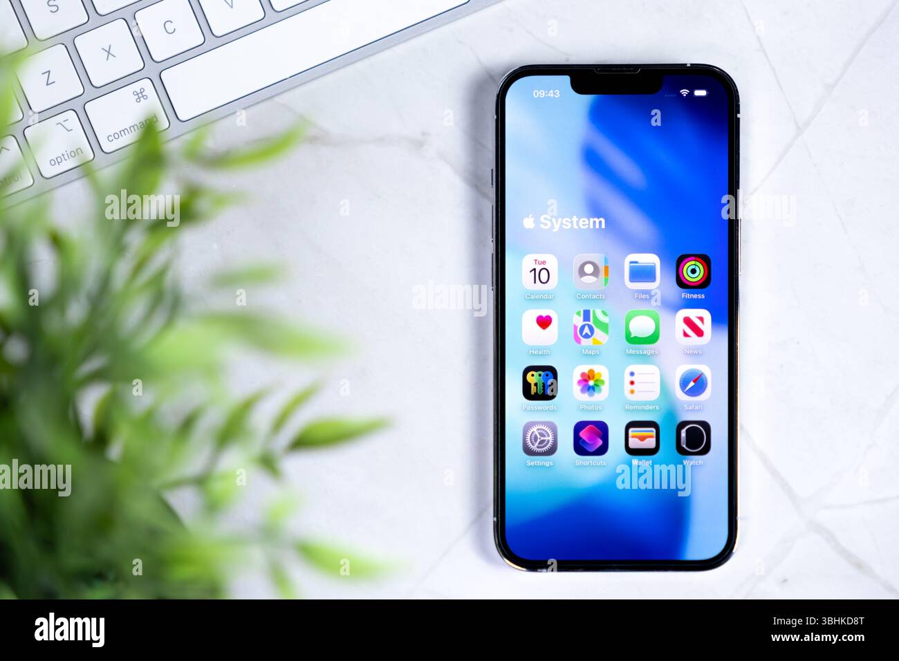 Poznan, Polonia - 10 giugno 2025: Smartphone che visualizza il nuovo iOS 26, vetro liquido nel design, sfondo blu brillante, testo di sistema e icone delle app Foto Stock