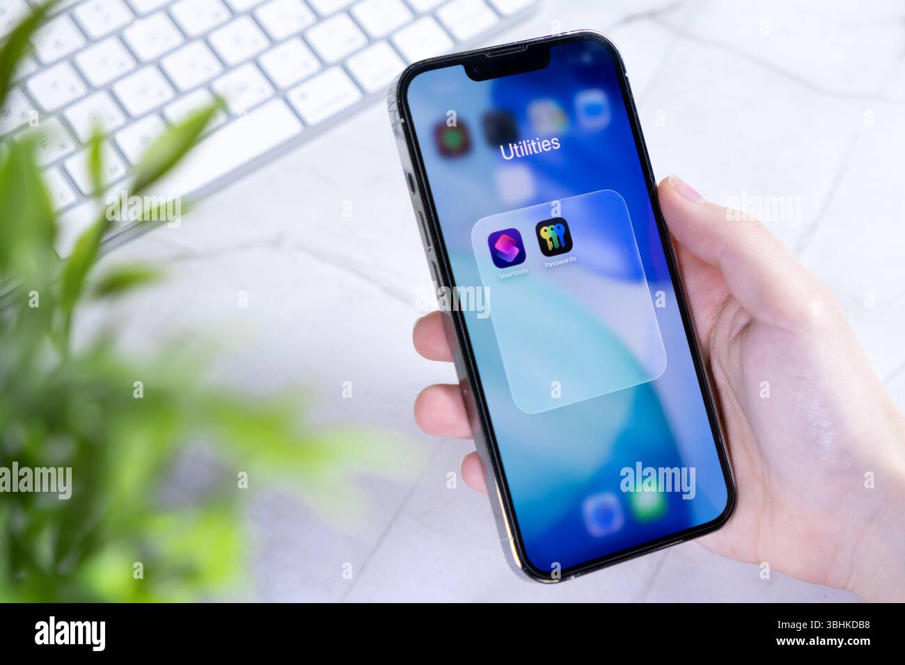 Poznan, Polonia - 10 giugno 2025: Primo piano di una mano che tiene uno smartphone con il nuovo design iOS 26 e Liquid Glass, che offre sicurezza e produttività Foto Stock