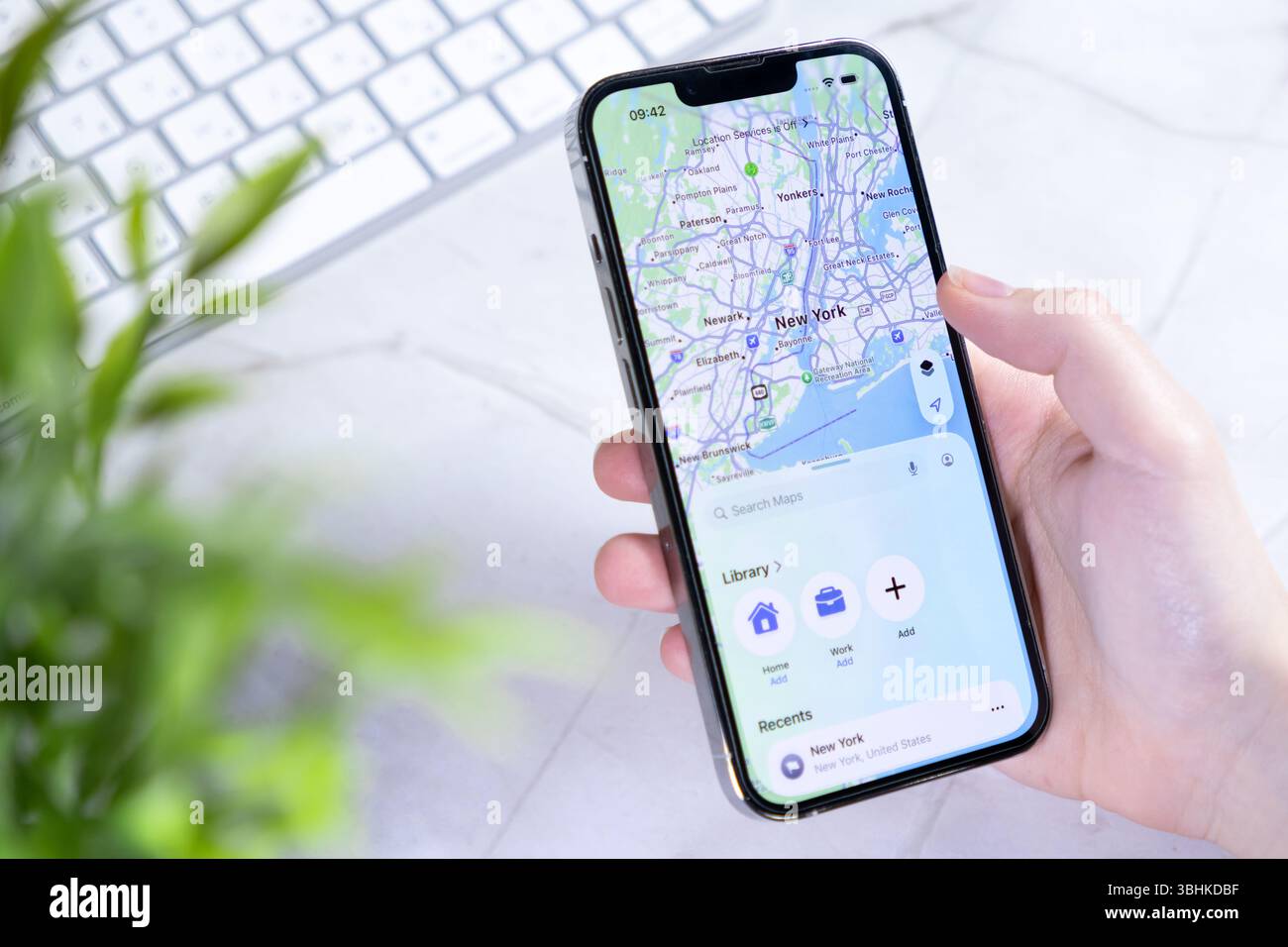 Poznan, Polonia - 10 giugno 2025: Questo smartphone contemporaneo con New iOS 26 Liquid Glass Design visualizza una mappa di New York, aiutando l'efficienza dell'ambiente urbano Foto Stock