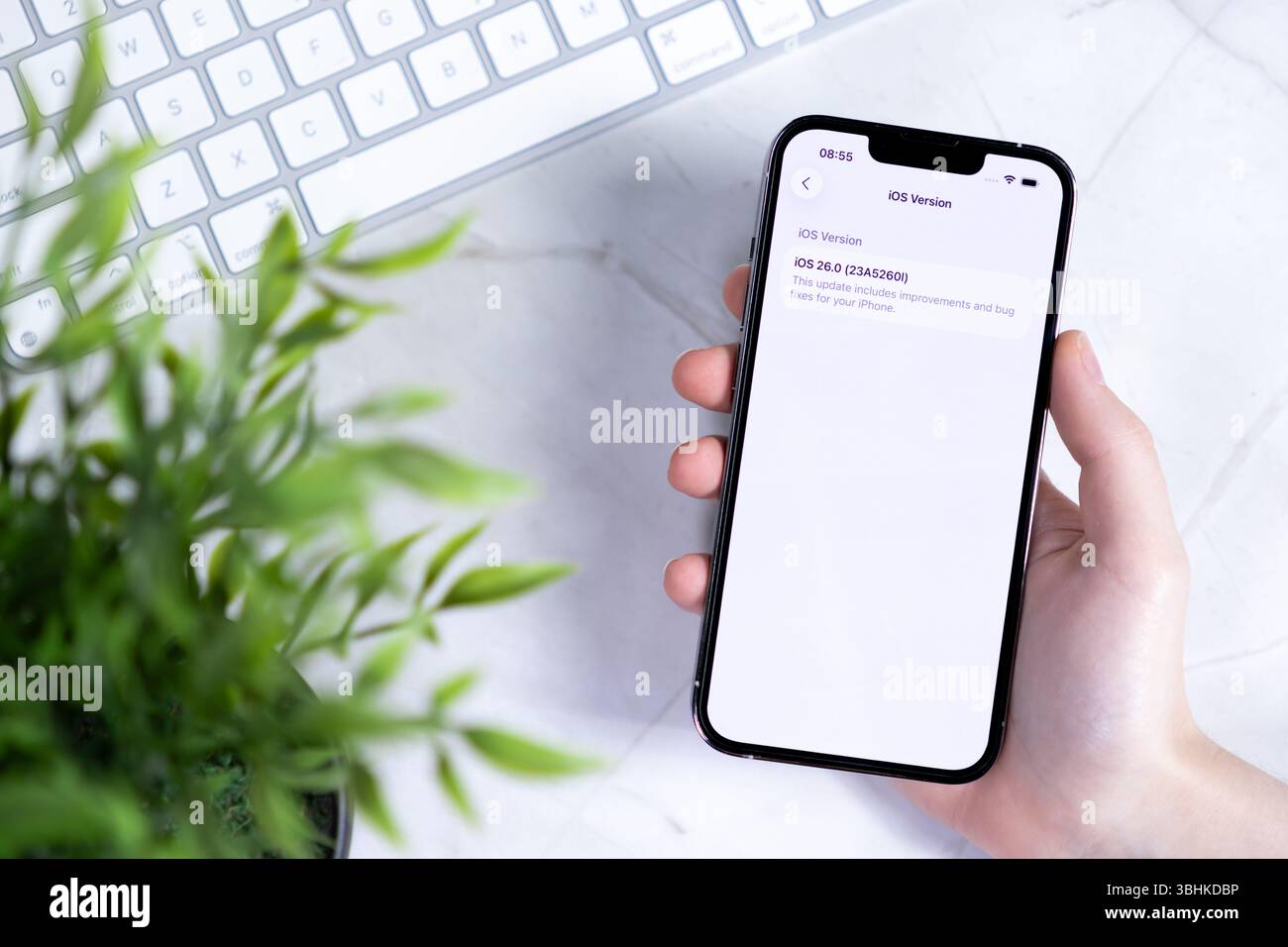 Poznan, Polonia - 10 giugno 2025: IPhone moderno tenuto in mano, che mostra l'aggiornamento del software iOS 26 con Liquid Glass NEL DESIGN, per una migliore espansione mobile Foto Stock
