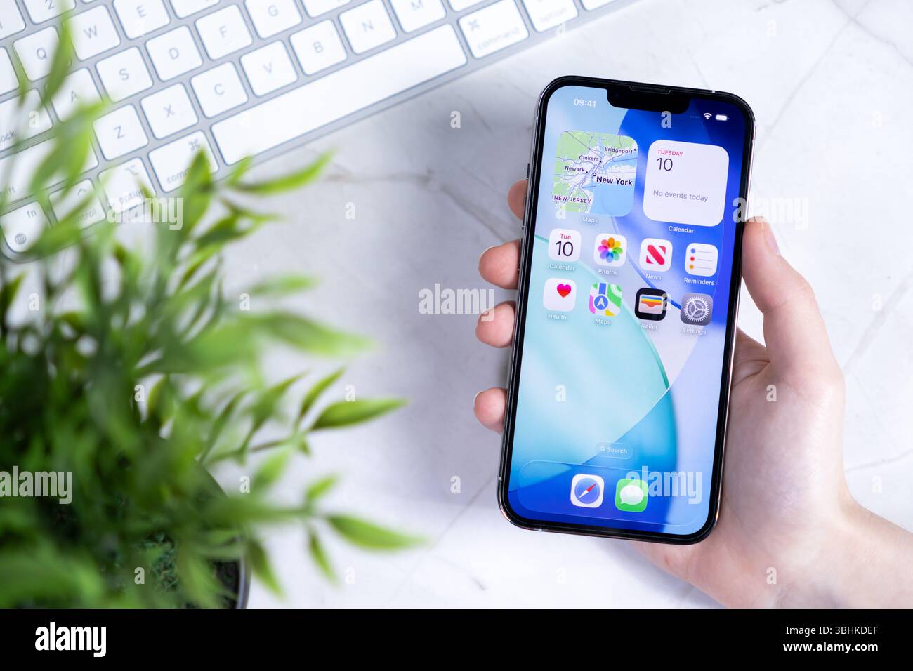 Poznan, Polonia - 10 giugno 2025: Primo piano della mano che interagisce con uno smartphone, presentando l'innovativo design iOS 26 Liquid Glass e il Foto Stock