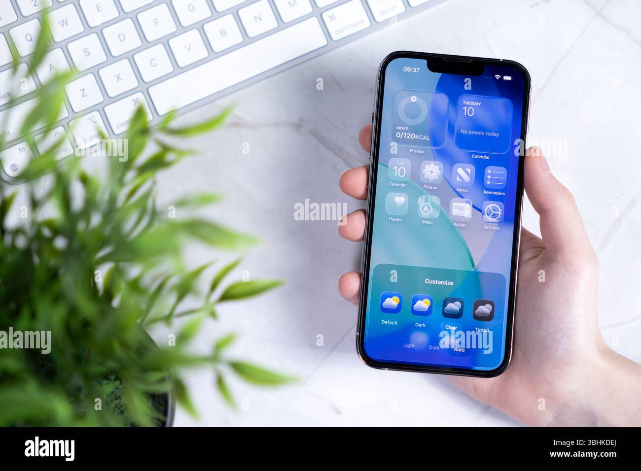 Poznan, Polonia - 10 giugno 2025: Primo piano di una mano che interagisce con un nuovo smartphone, con iOS 26 dal design Liquid Glass e customizabl Foto Stock