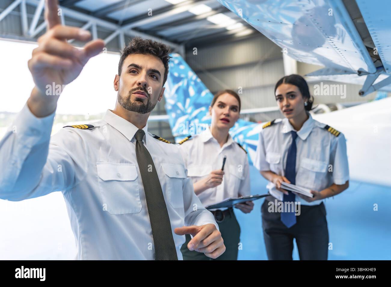 Equipaggio di manutenzione dell’aviazione che esamina l’ala del velivolo, garantendo la sicurezza e la funzionalità prima del volo Foto Stock