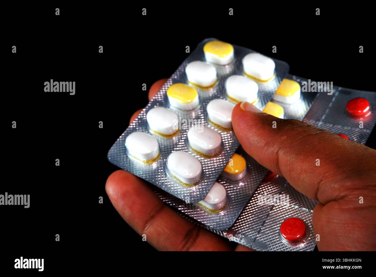 Le compresse di zucchero si stringono per mano su sfondo nero vista ravvicinata Foto Stock