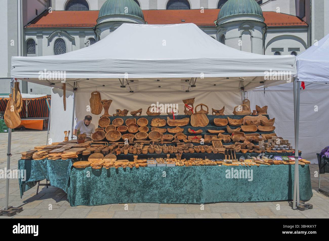 Mercato settimanale con bancarelle che vendono ciotole e tavole di legno di fronte alla chiesa di Lorenzkirche in Hildegardplatz, Kempten, Allgaeu, Svevia, Baviera, Ger Foto Stock