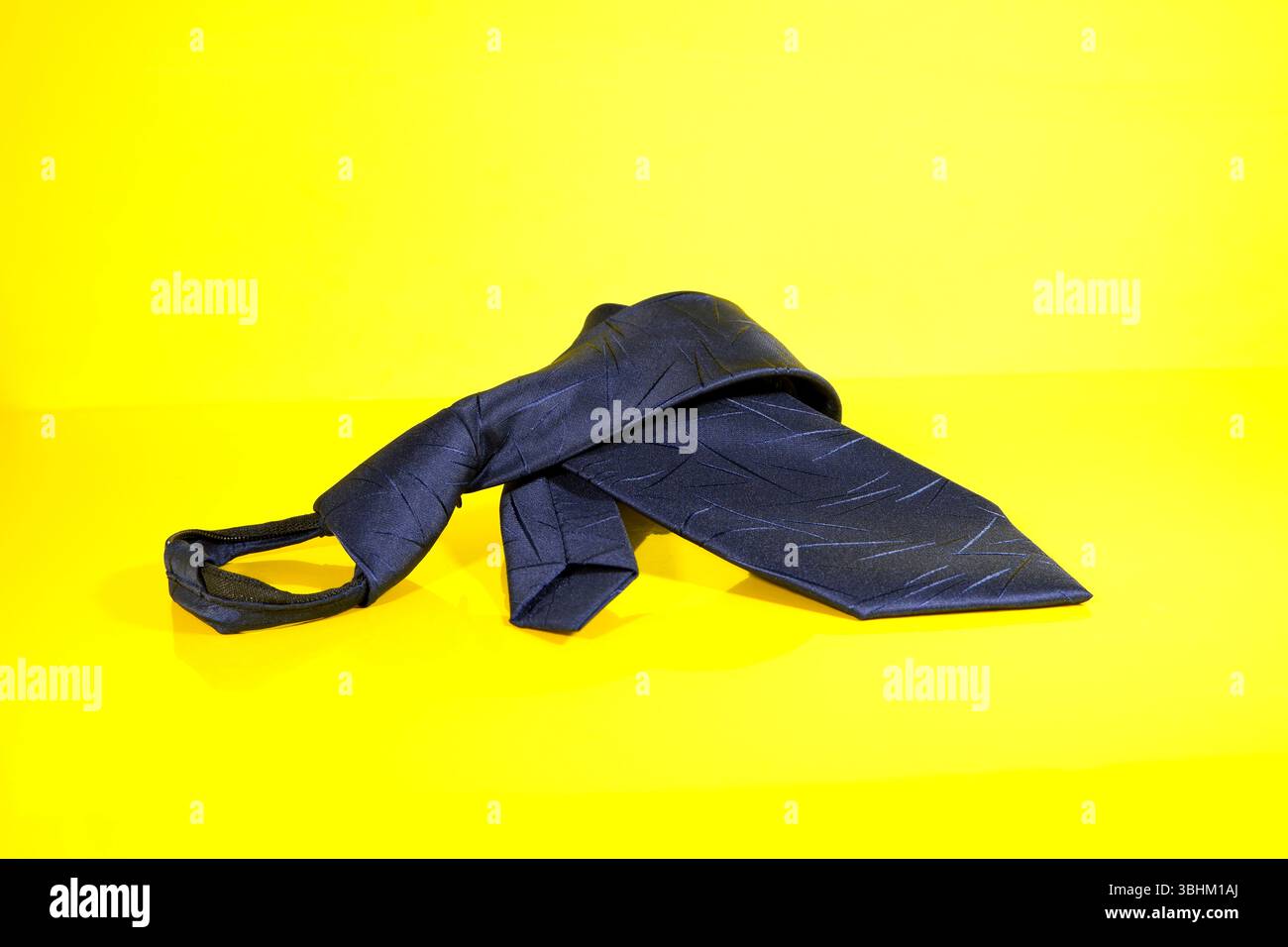 Una cravatta con zip isolata su sfondo giallo vista ravvicinata Foto Stock