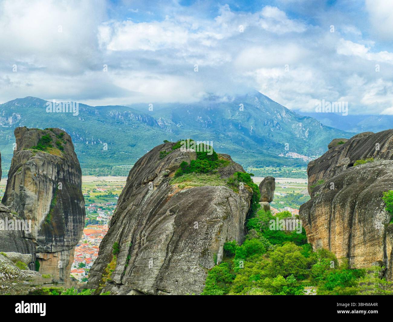 METERORA, GFEECE - 11 MAGGIO 2025 - suggestivi pinnacoli di roccia che sorgono in mezzo a un paesaggio verdeggiante, antichi monasteri annidati sullo sfondo montuoso Foto Stock