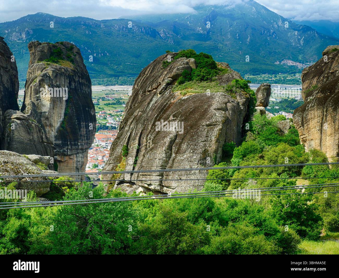METERORA, GFEECE - 11 MAGGIO 2025 - torri calcaree di Meteora che si innalzano sopra un paesaggio verdeggiante sotto la luce del sole Foto Stock