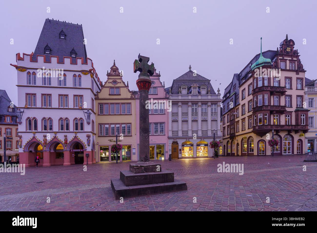 Treviri, Germania - 12 ottobre 2024: Scena dell'alba di Foggy in piazza Hauptmarkt, con vari edifici, locali e visitatori, a Treviri, Renania-Pala Foto Stock