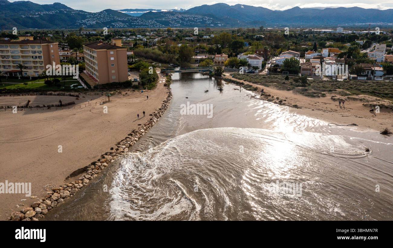 Denia, Alicante - Spagna - 11-13-2024: Vista aerea di un fiume che scorre tra due spiagge nel mare, con persone che camminano lungo la riva. Foto Stock