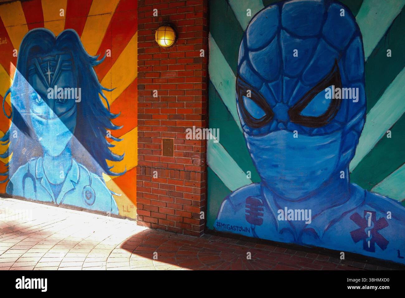 Wonder Woman & Spider-Man indossare maschere in un murale di sostegno operatori sanitari durante Covid-19, Water Street, Gastown, Vancouver, BC. Foto Stock