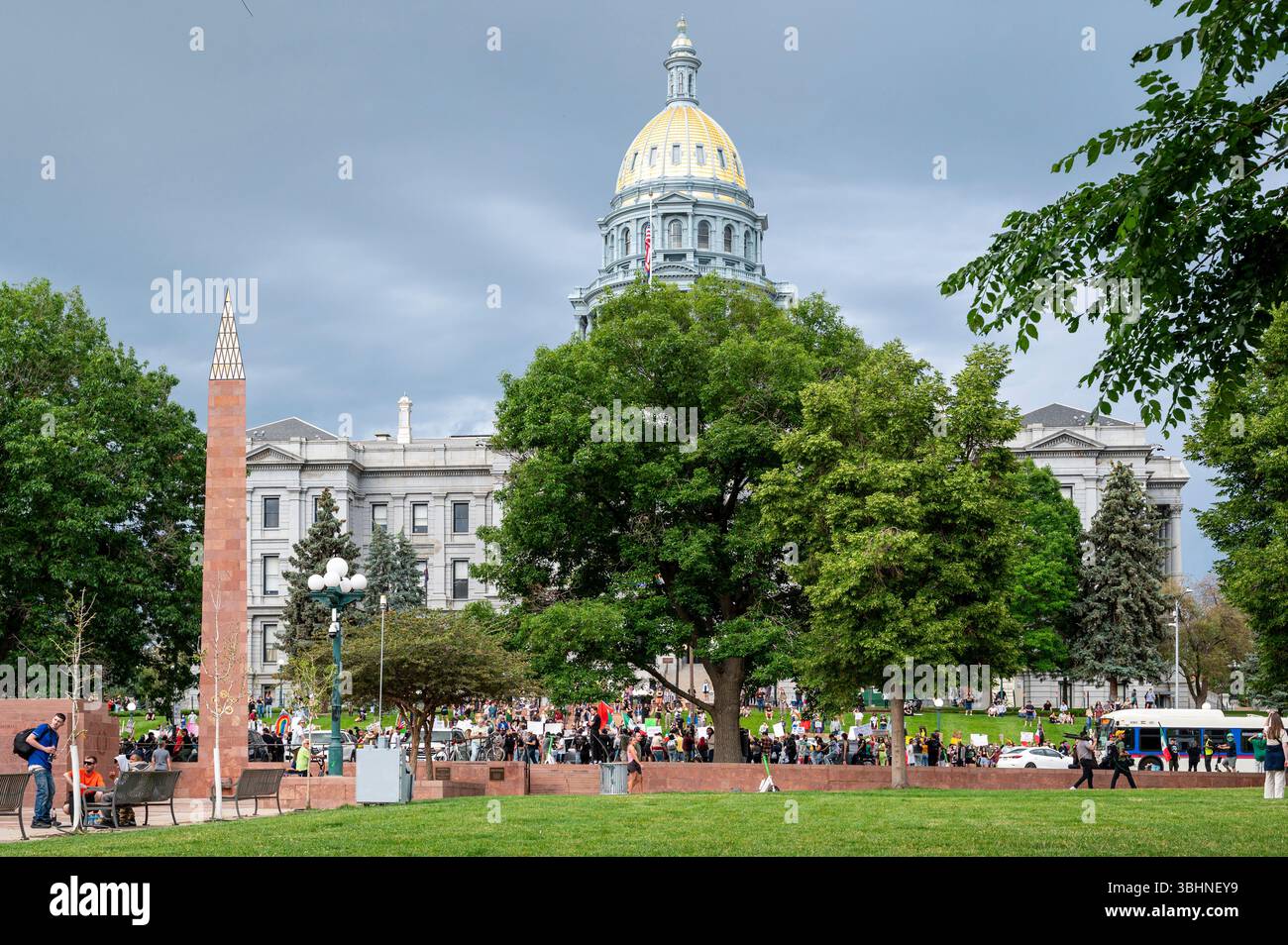 Folla radunata al Colorado State Capitol con cupola dorata nel parco di Denver durante una manifestazione pubblica Foto Stock