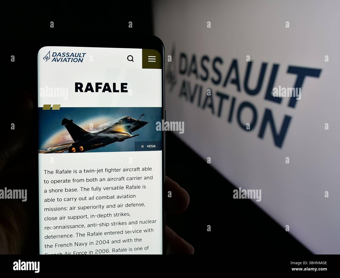 Stoccarda, Germania - 03-13-2025: Persona che detiene il cellulare con pagina web della società francese Dassault Aviation S.A. sullo schermo davanti al logo. Foto Stock