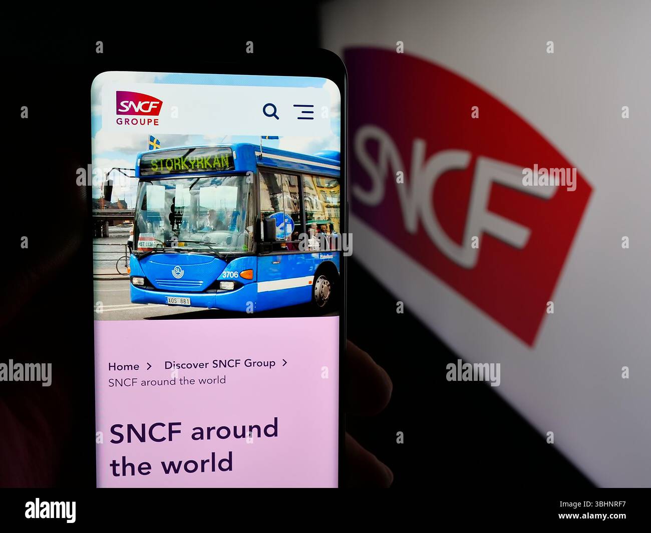 Stoccarda, Germania - 03-20-2025: Persona che detiene un cellulare con pagina web del gruppo ferroviario francese SNCF sullo schermo davanti al logo. Foto Stock