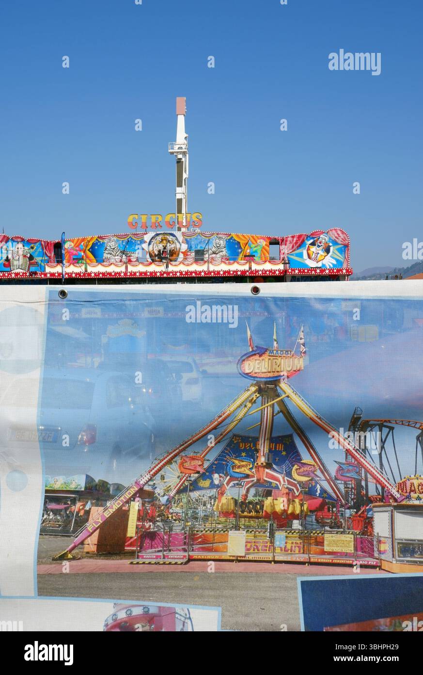 fiera del divertimento dietro la recinzione del telone Foto Stock