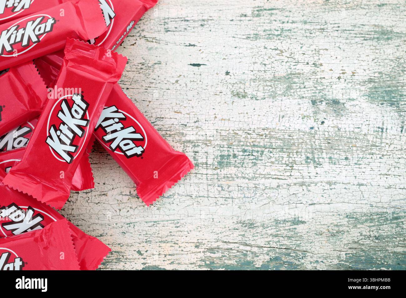 Barrette di cioccolato Kit Kat pacchetti su un vecchio sfondo in legno, cibo e spuntini. Kit Kat è una bacchetta di wafer ricoperta di cioccolato Foto Stock